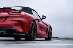 JR Wheels JR50 Bronze alloy wheel mounted on car in an atmospheric setting