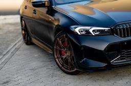 JR Wheels JR50 Bronze alloy wheel mounted on car in an atmospheric setting