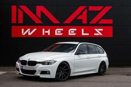 Imaz Wheels IM5R Black alloy wheel mounted on car in an atmospheric setting
