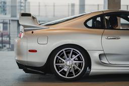Imaz Wheels IM5R Silver alloy wheel mounted on car in an atmospheric setting