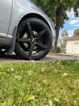 Imaz Wheels IM14 Musta alumiinivanteet asennettuna autoon tunnelmallisessa ympäristössä