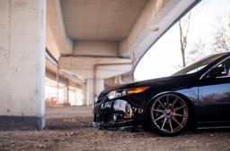 JR Wheels JR11 Bronze alloy wheel mounted on car in an atmospheric setting