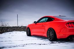 JR Wheels JR11 Bronze alloy wheel mounted on car in an atmospheric setting