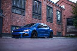 JR Wheels JR11 Black alloy wheel mounted on car in an atmospheric setting