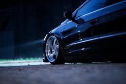 JR Wheels JR15 Silver alloy wheel mounted on car in an atmospheric setting