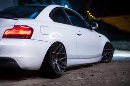 JR Wheels JR18 Bronze alloy wheel mounted on car in an atmospheric setting