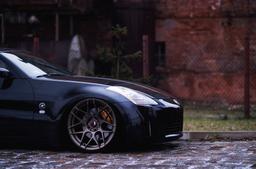 JR Wheels JR18 Bronze alloy wheel mounted on car in an atmospheric setting