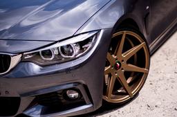 JR Wheels JR20 Bronze alloy wheel mounted on car in an atmospheric setting
