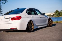 JR Wheels JR20 Bronze alloy wheel mounted on car in an atmospheric setting