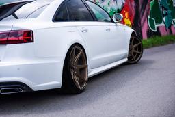 JR Wheels JR20 Bronse aluminiumsfelger montert på bil i en stemningsfull omgivelse