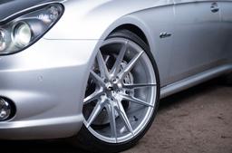 JR Wheels JR21 Silver alloy wheel mounted on car in an atmospheric setting