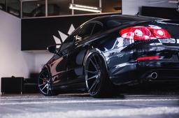 JR Wheels JR21 Black alloy wheel mounted on car in an atmospheric setting