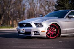 JR Wheels JR21 Red alloy wheel mounted on car in an atmospheric setting