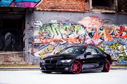 JR Wheels JR21 Red alloy wheel mounted on car in an atmospheric setting