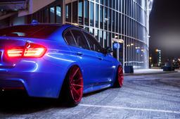 JR Wheels JR21 Red alloy wheel mounted on car in an atmospheric setting