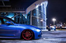 JR Wheels JR21 Red alloy wheel mounted on car in an atmospheric setting