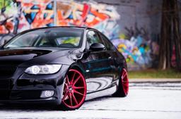 JR Wheels JR21 Red alloy wheel mounted on car in an atmospheric setting