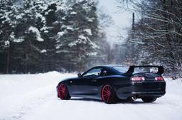 JR Wheels JR21 Red alloy wheel mounted on car in an atmospheric setting