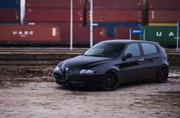 JR Wheels JR22 Svart aluminiumsfelger montert på bil i en stemningsfull omgivelse