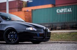 JR Wheels JR22 Black alloy wheel mounted on car in an atmospheric setting