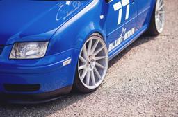 JR Wheels JR22 Silver alloy wheel mounted on car in an atmospheric setting