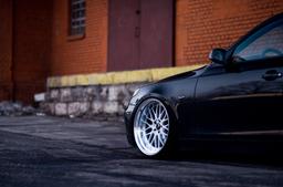 JR Wheels JR23 Silver alloy wheel mounted on car in an atmospheric setting