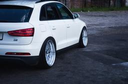 JR Wheels JR23 Sølv aluminiumsfelger montert på bil i en stemningsfull omgivelse