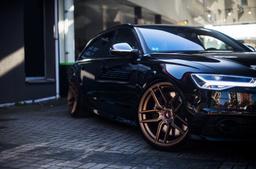 JR Wheels JR25 Bronze alloy wheel mounted on car in an atmospheric setting
