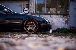 JR Wheels JR25 Bronze alloy wheel mounted on car in an atmospheric setting