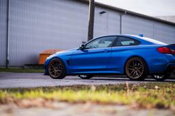 JR Wheels JR25 Brons aluminiumfälg monterade på bil i stämnigsfull miljö