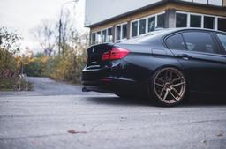 JR Wheels JR25 Bronze alloy wheel mounted on car in an atmospheric setting