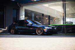 JR Wheels JR25 Bronze alloy wheel mounted on car in an atmospheric setting