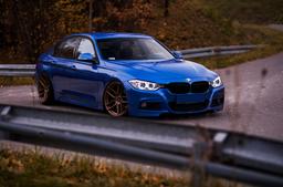 JR Wheels JR25 Bronze alloy wheel mounted on car in an atmospheric setting