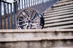 JR Wheels JR25 Grå aluminiumfälg monterade på bil i stämnigsfull miljö