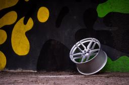 JR Wheels JR25 Silver alloy wheel mounted on car in an atmospheric setting