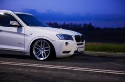 JR Wheels JR25 Silver alloy wheel mounted on car in an atmospheric setting