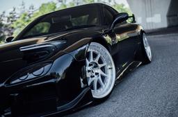 JR Wheels JR26 Silver alloy wheel mounted on car in an atmospheric setting