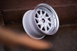 JR Wheels JR26 White alloy wheel mounted on car in an atmospheric setting