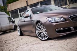 JR Wheels JR28 Silver alloy wheel mounted on car in an atmospheric setting