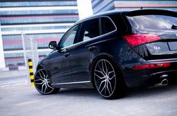 JR Wheels JR28 Black alloy wheel mounted on car in an atmospheric setting