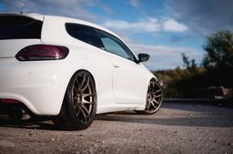 JR Wheels JR29 Brons aluminiumfälg monterade på bil i stämnigsfull miljö