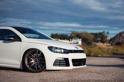 JR Wheels JR29 Bronze alloy wheel mounted on car in an atmospheric setting