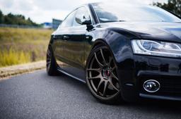 JR Wheels JR29 Bronse aluminiumsfelger montert på bil i en stemningsfull omgivelse