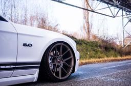 JR Wheels JR30 Bronse aluminiumsfelger montert på bil i en stemningsfull omgivelse