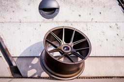 JR Wheels JR30 Bronse aluminiumsfelger montert på bil i en stemningsfull omgivelse
