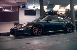 JR Wheels JR30 Brons aluminiumfälg monterade på bil i stämnigsfull miljö