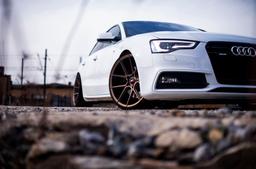 JR Wheels JR30 Bronse aluminiumsfelger montert på bil i en stemningsfull omgivelse