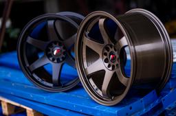 JR Wheels JR3 Brons aluminiumfälg monterade på bil i stämnigsfull miljö