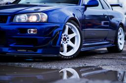 JR Wheels JR3 White alloy wheel mounted on car in an atmospheric setting