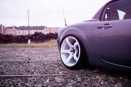 JR Wheels JR32 White alloy wheel mounted on car in an atmospheric setting